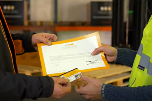 Profesor del curso de carretillas trekform entregando acreditación tamaño carnet y certificado de capacitación.